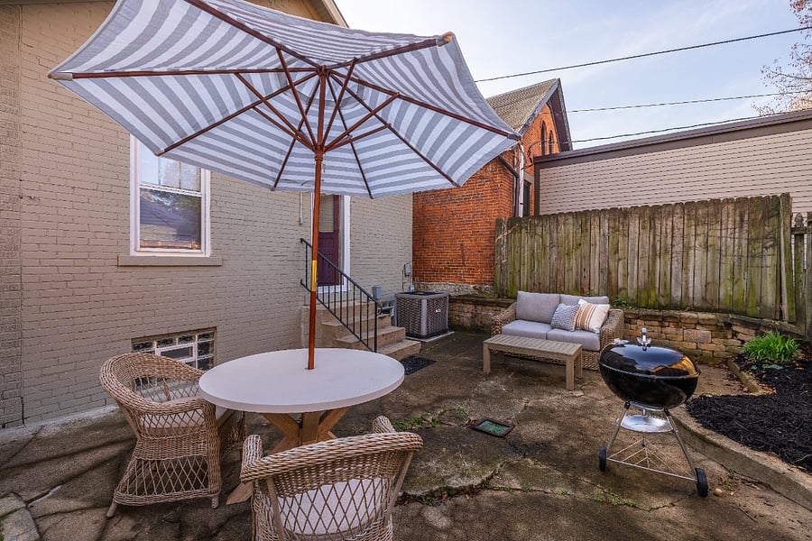 Private, fenced back patio has sun and shade, outdoor eating and seating, and a Weber grill