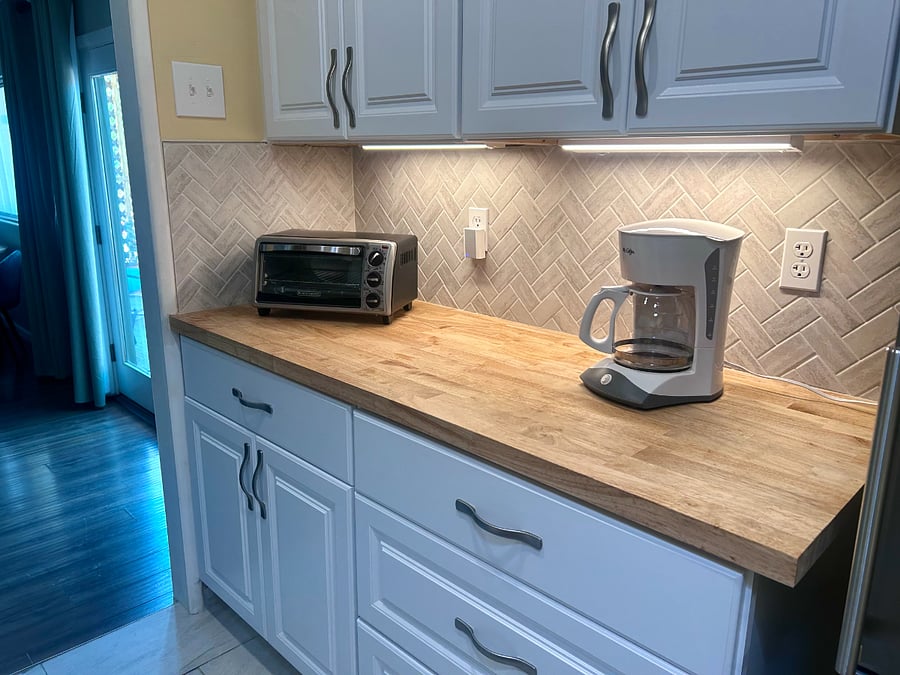 Bright galley kitchen with apartment-size appliances, modern finishes, and thoughtfully designed workspace