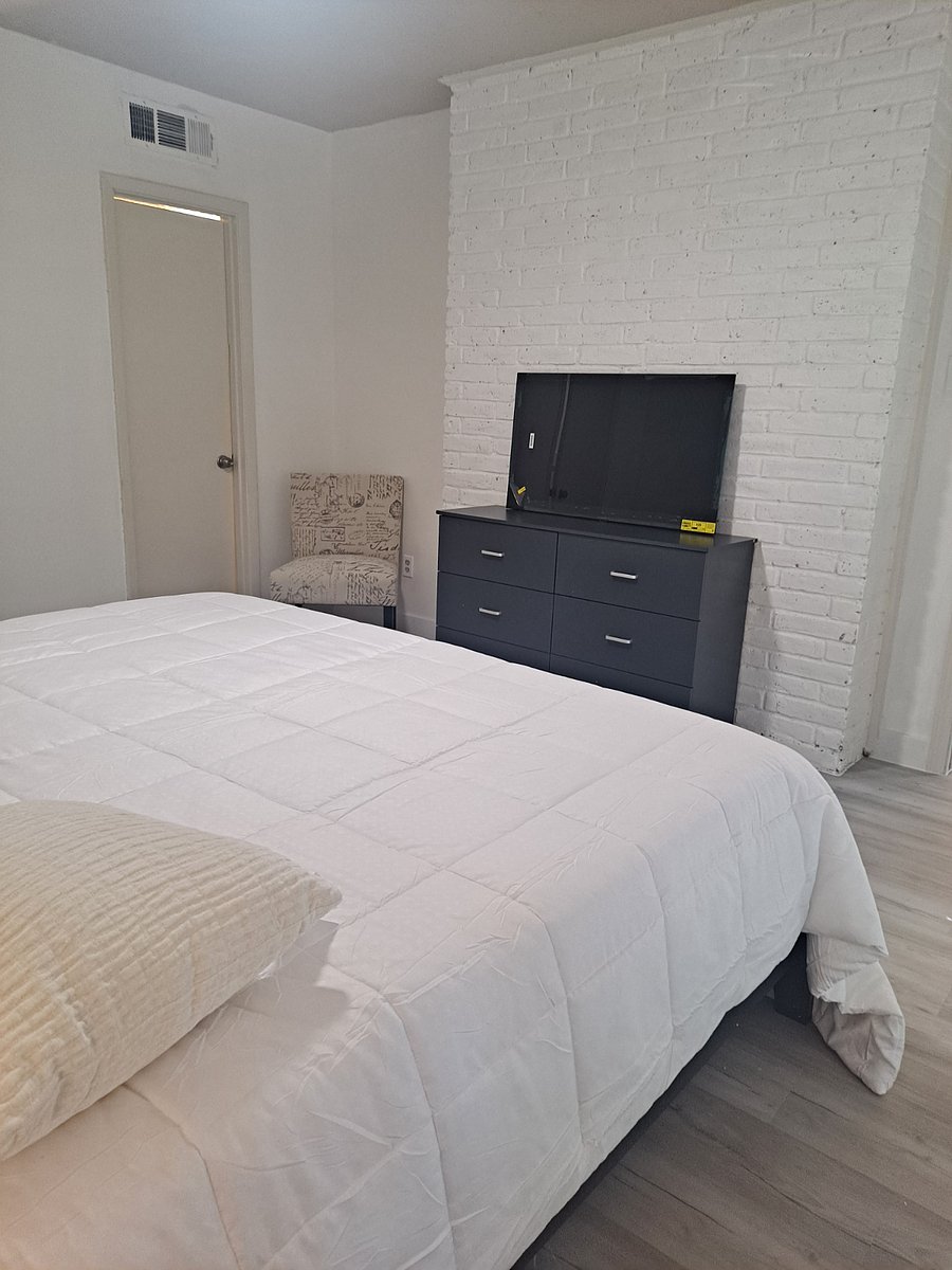 Front angle of primary bedroom with TV and comfortable chair