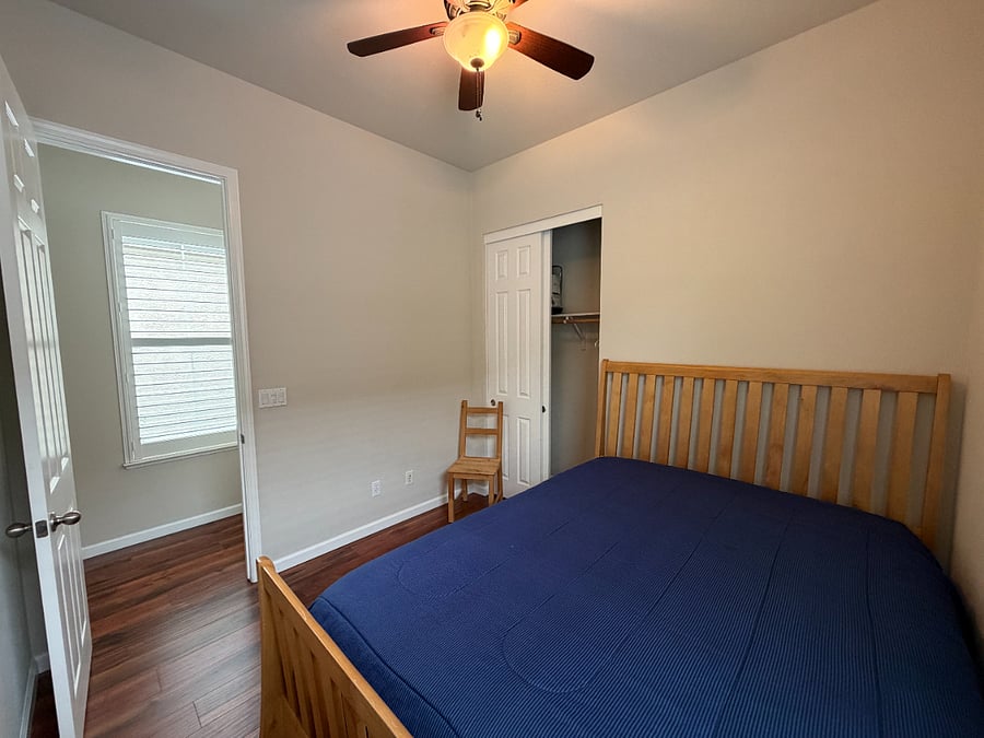 The view out the door of the middle bedroom, into the hall. There are two windows which illuminate the hall from the main entryway to the house.