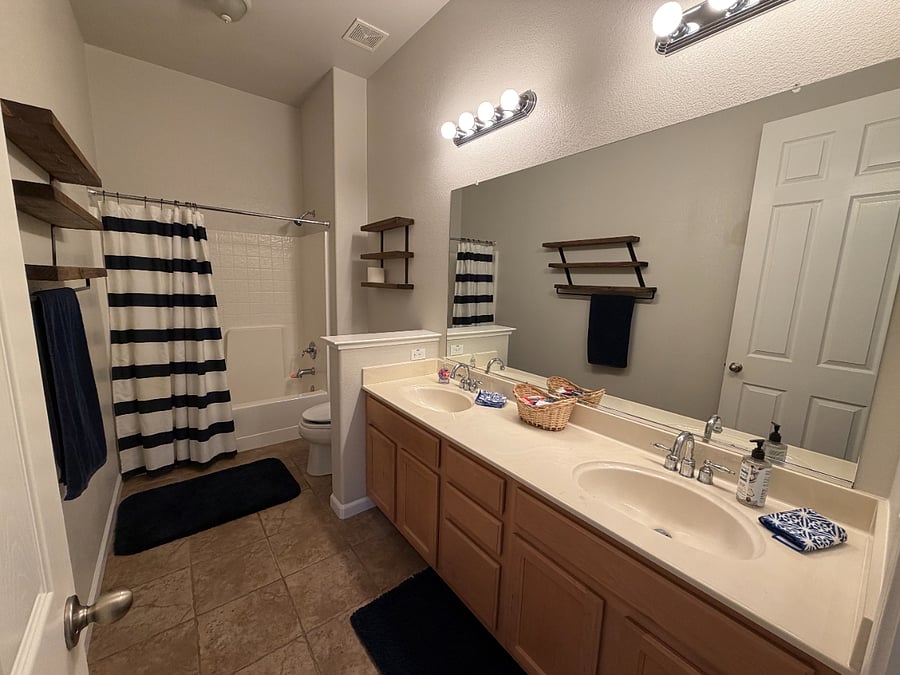 A nice full bath with double sinks. Also serves as guest bathroom, between extra bedrooms and pool table.