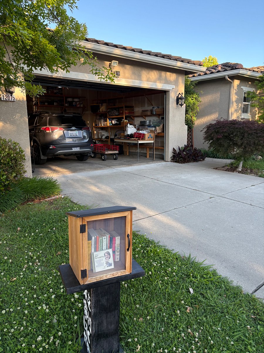 The view of my car in the garage and our nice wide driveway. Entrance is to the right, thru an arch. Thats my Little Free Library out front. Please use it!