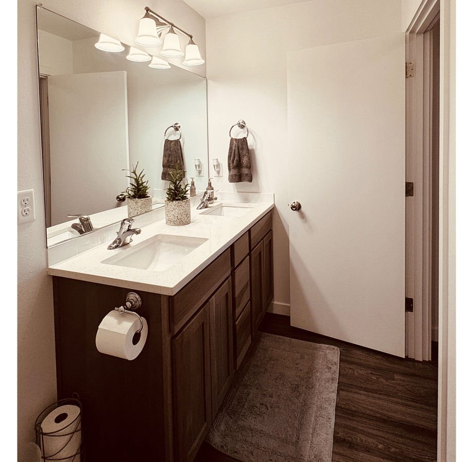 Private Bathroom with Quartz Countertop, Large Mirror, Double Sinks, and Ample Storage