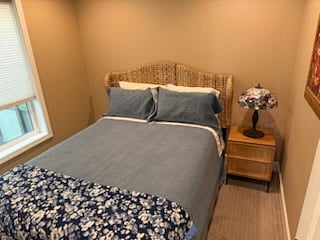 Bedroom with queen-sized bed and night stand.