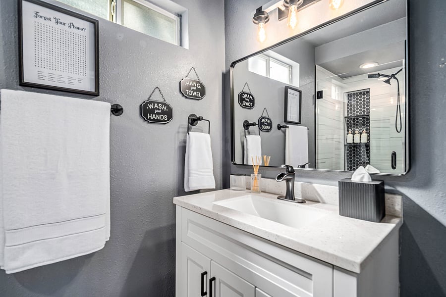 Modern Farmhouse Bathroom  Deep walk-in shower with black, white & gray tones, stocked with shower essentials. With spa-like spot lighting for a relaxing experience after a long day.

