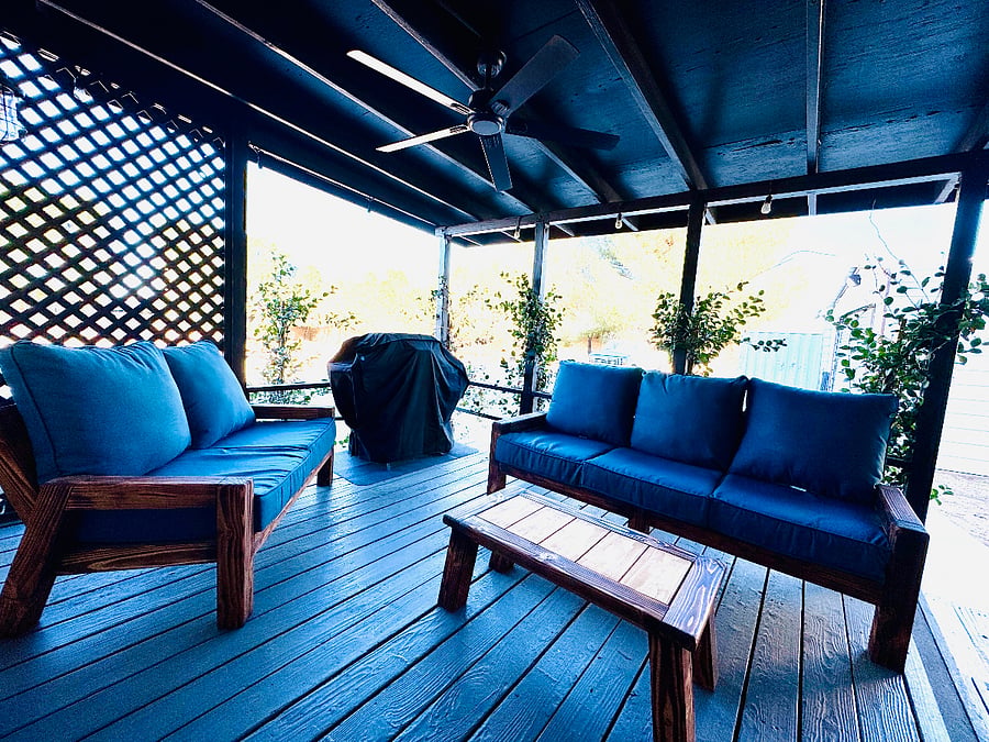 Elevated Back Porch  Accessible through French doors off the main dining room, this inviting, covered deck features comfortable custom-made sofas, a Persian-style area rug, and a BBQ for outdoor dining. Surrounded by lush jasmine vines, the space offers a private, relaxing atmosphere enhanced by a ceiling fan, string lights, and a misting systemperfect for enjoying warm evenings in comfort.


