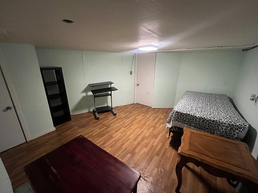Room 1 with standup desk, bookshelf and twin bed, closet rod to hang clothing