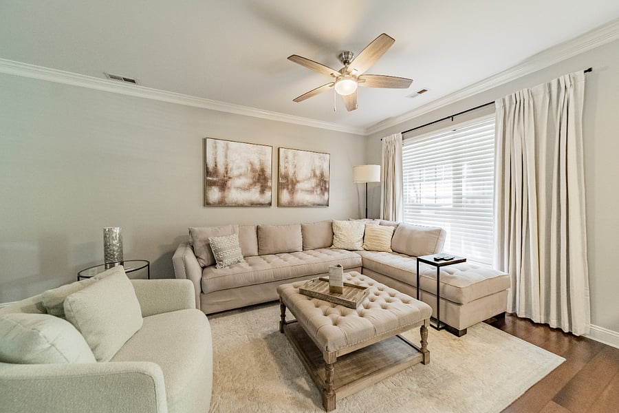 spacious living room with sectional sofa and ceiling fan