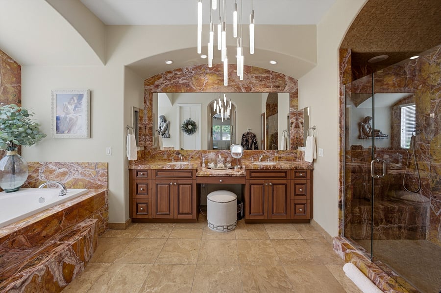 Primary Bedroom Bathroom with extensive granite accents, raised spa tub, and granite shower stall.