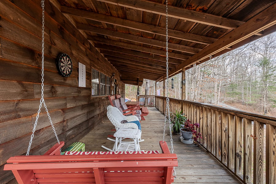 Porch swing on the front porch with rocking chairs and bird feeders.