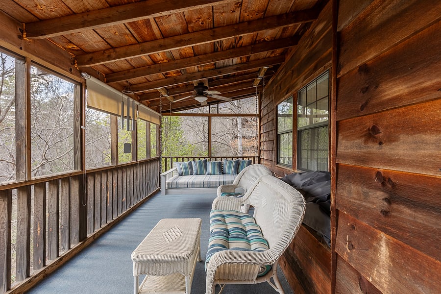 Patio furniture on screened porch facing west with roll down curtains. 
