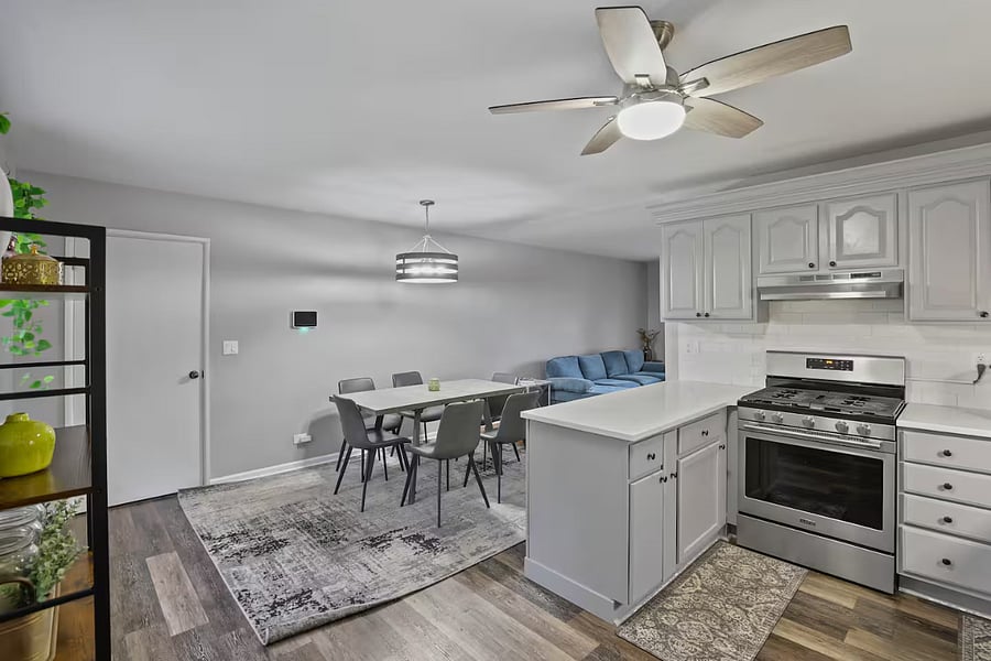 Kitchen with a stove, oven, refrigerator, freezer, dishwasher, toaster, blender, and hot water kettle, cooking basics, baking sheets, dishes, silverware, wine glasses, and a coffee maker with coffee.