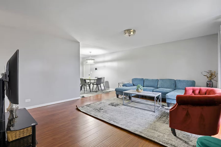 Living room with sleeper couch, smart TV and closet space.