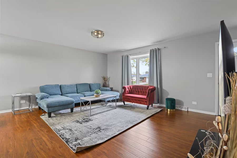 Living room with sleeper couch, smart TV and closet space.