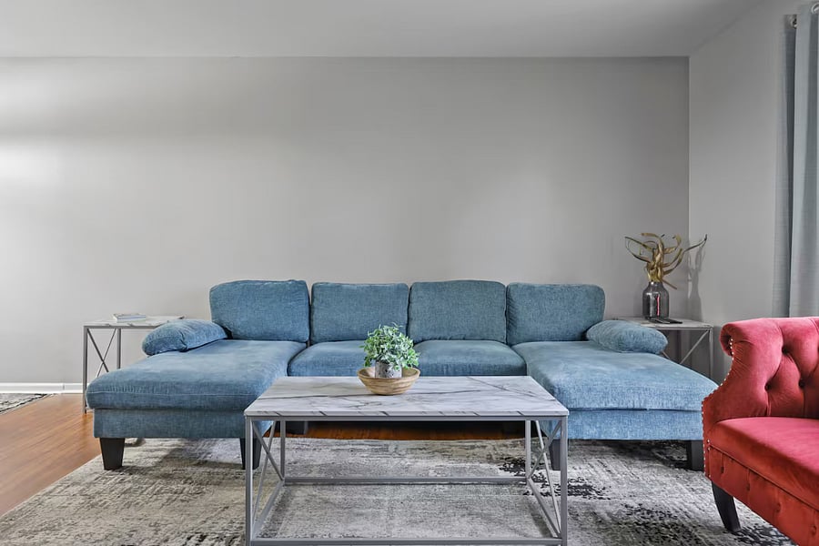 Living room with sleeper couch, smart TV and closet space.