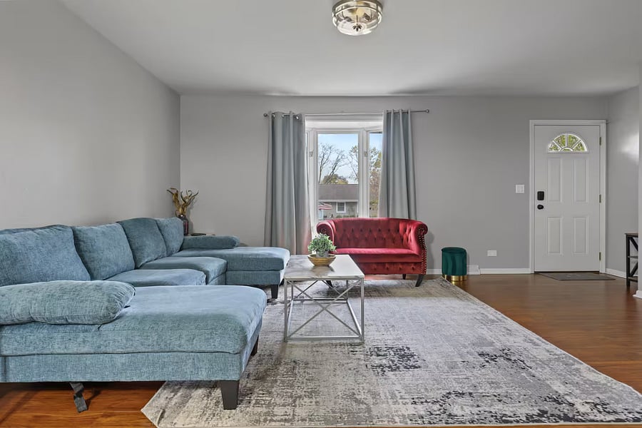Living room with sleeper couch, smart TV and closet space.