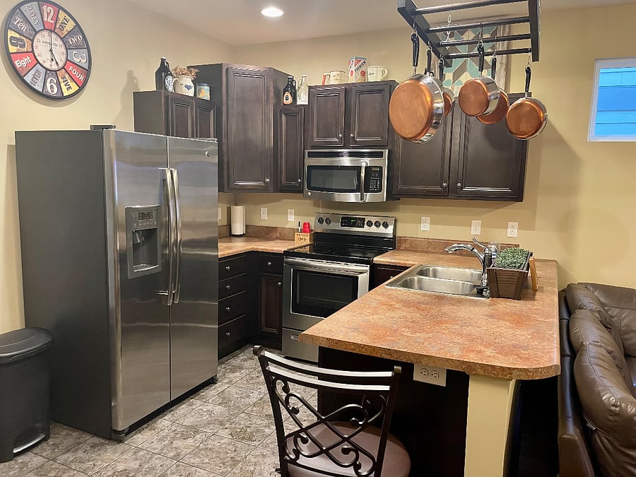 Kitchen includes coffee maker, blender and toaster as well as dishes and silverware.