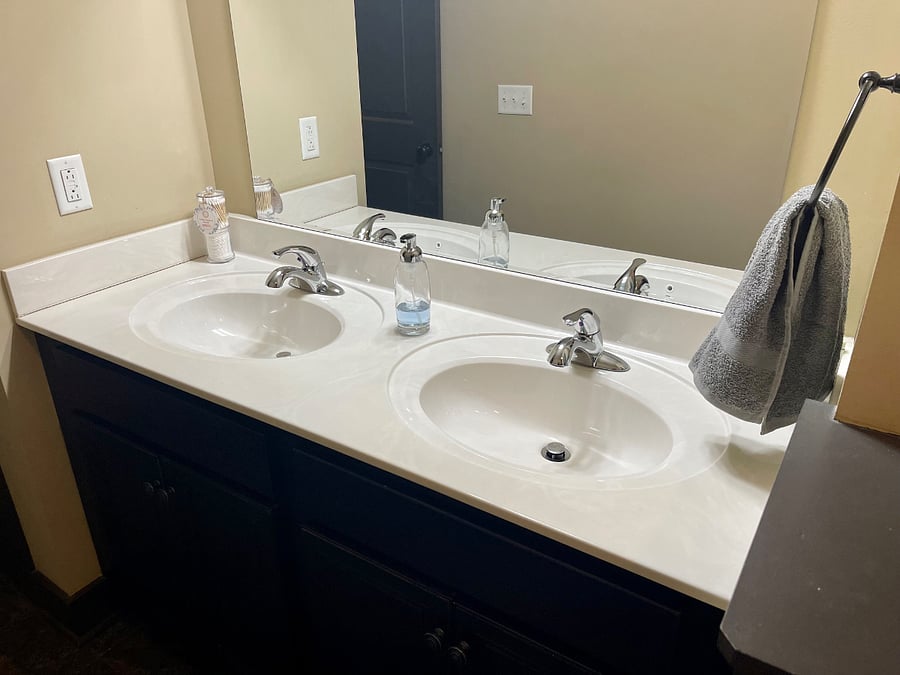 Primary suite's bathroom with double vanity and tub/shower combo