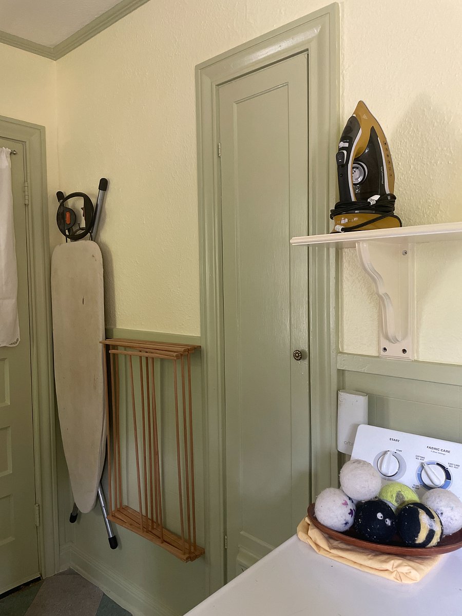 Ironing board & iron & are beside the Washer & Dryer in the kitchen.