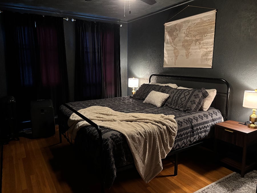 Master Bedroom w/ kind sized bed, blackout curtains, desk, office chair, & walk-in closet