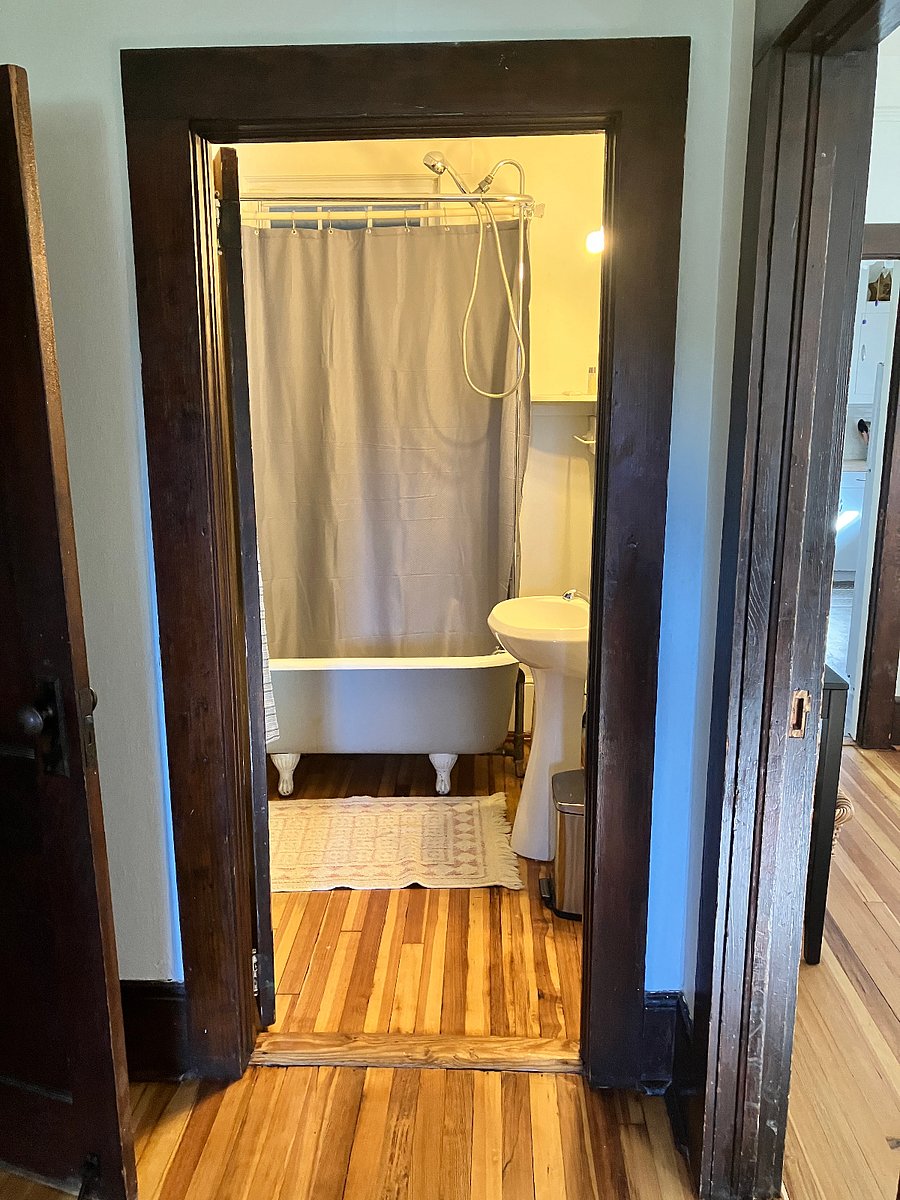 The bathroom at the end of the hall has a claw-foot tub.