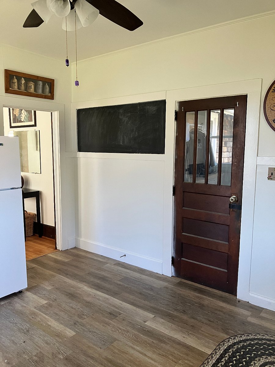 Standing in the kitchen. The door leads to the laundry area and then out to the back patio. There's a blackboard on the wall for you to practice your chalk art skills. ;)