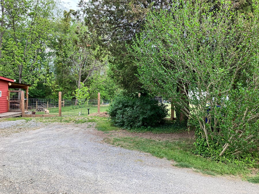 The parking area is behind the house; it fits three cars side by side, and more can fit behind them.