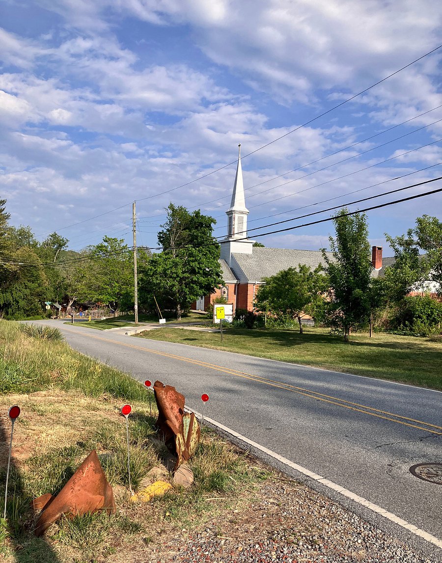 Looking east. The former church is now Haw Creek Commons, a community space for classes, meetings, and other gatherings.
The scrap metal "sculpture" at the end of the driveway is to keep delivery trucks from cutting the corner.