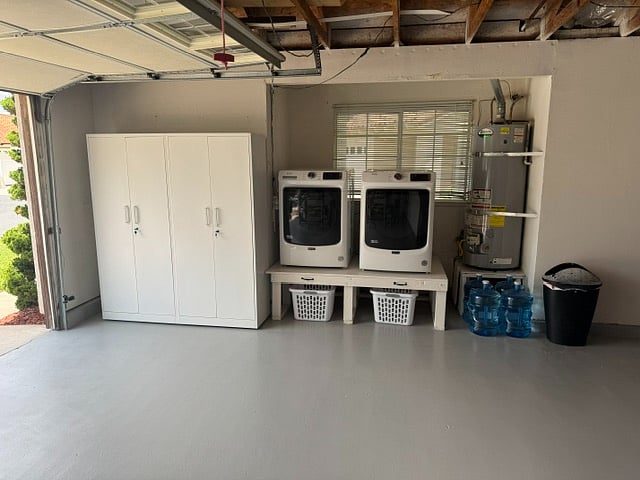 Large capacity washer & gas dryer elevated to a convenient height and clothes baskets at the ready. Lights overhead.