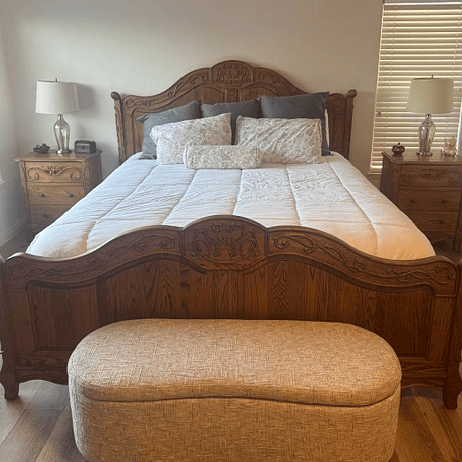 California King with hand carved oak headboard & footboard in master bedroom. Comfortable bend at the end of the bed with storage space.