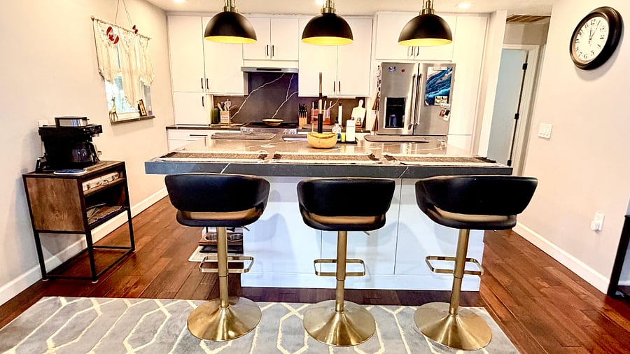 Kitchen bar seating with modern lighting and open layout.