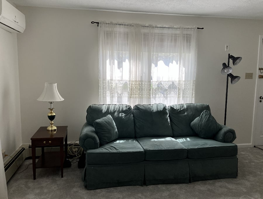 Living room with couch, chair, tv, corner hutch, lamps and end tables