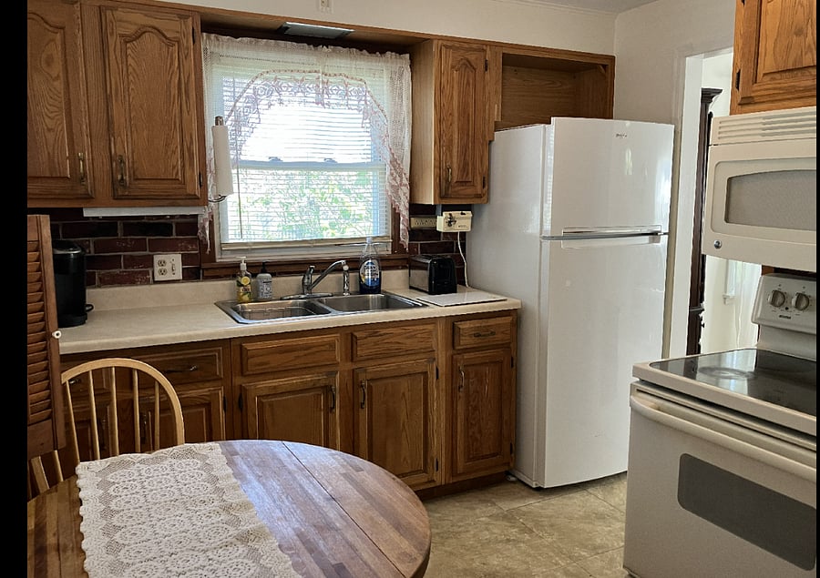 kitchen with sink and refrigerator, stove, microwave, oak table