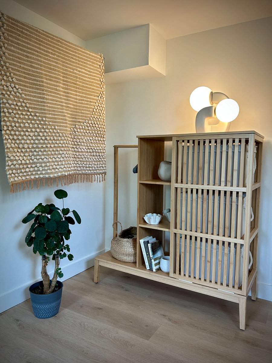 The TV is concealed behind the tapestry, and the wardrobe offers additional storage behind the sliding slatted door.