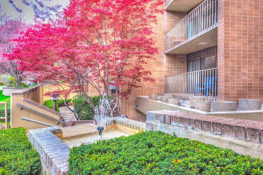 Building exterior, Condo features 2 private patios with mature trees and lovely landscaping.