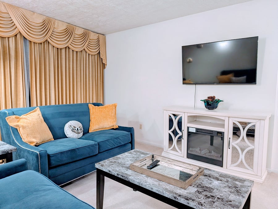 Large living room with electric fireplace and TV