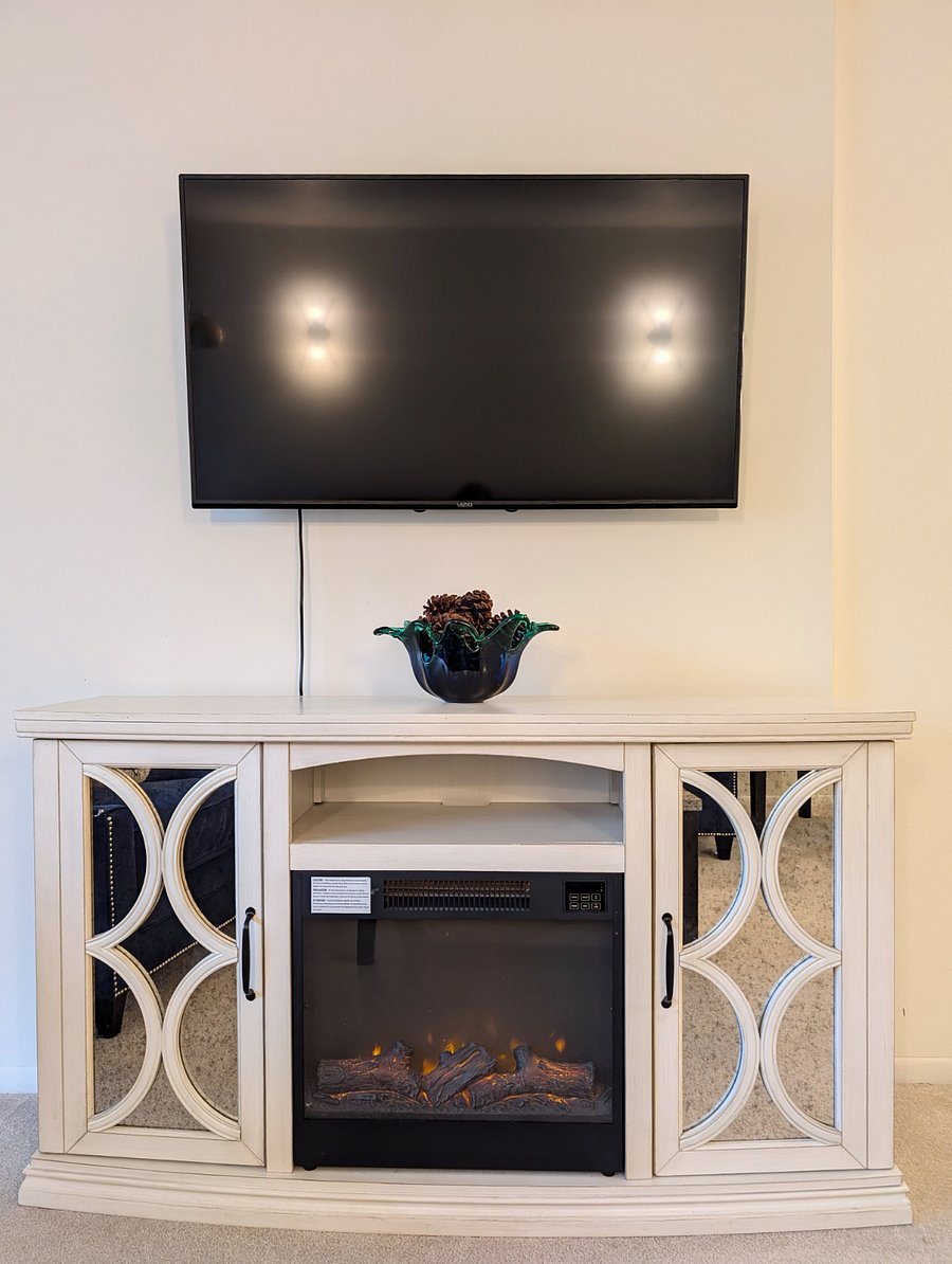 Large living room with electric fireplace and TV