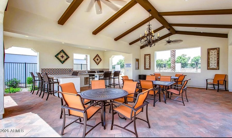 Covered community seating area with fireplace and shaded dining space.
