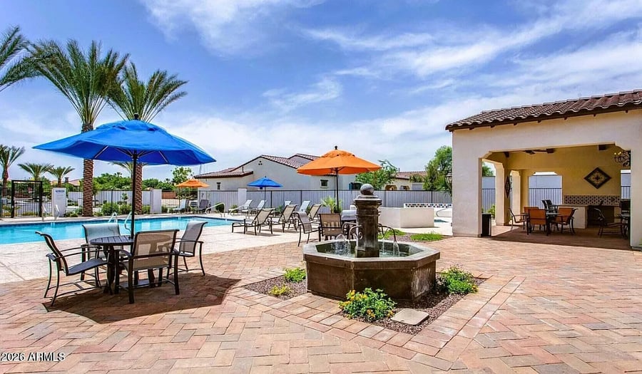 Shaded outdoor dining space with fire pit and poolside views.