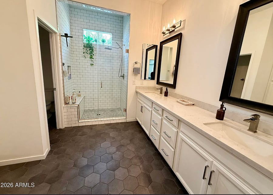 Updated bathroom with dual sinks, walk-in shower, and plenty of counter space.