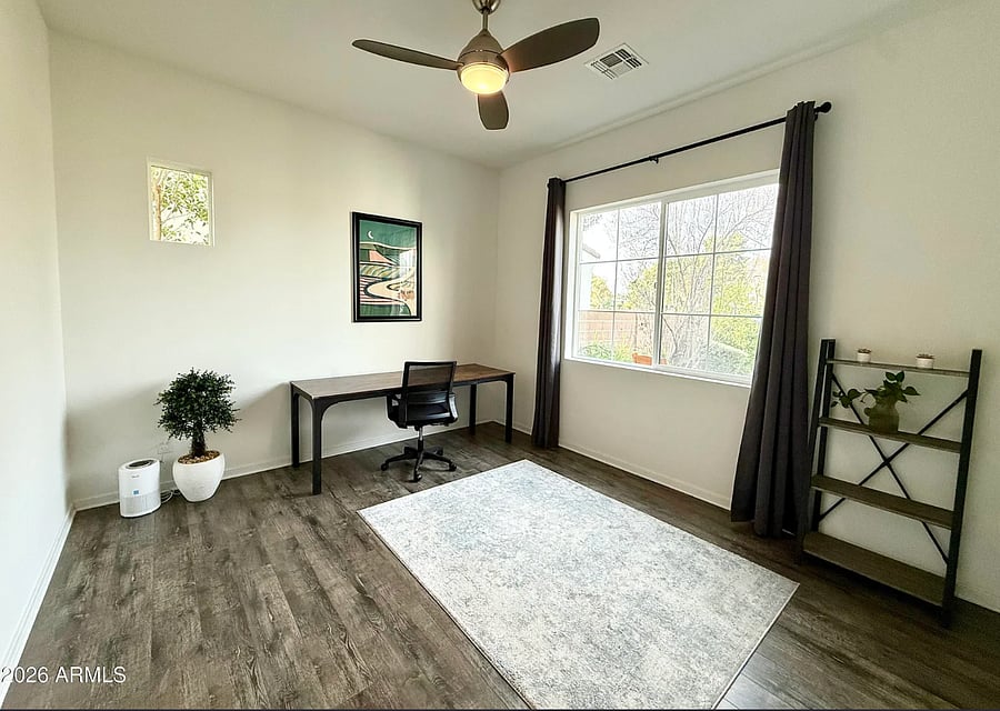 Comfortable guest bedroom/office with warm tones and plenty of space for a restful stay.