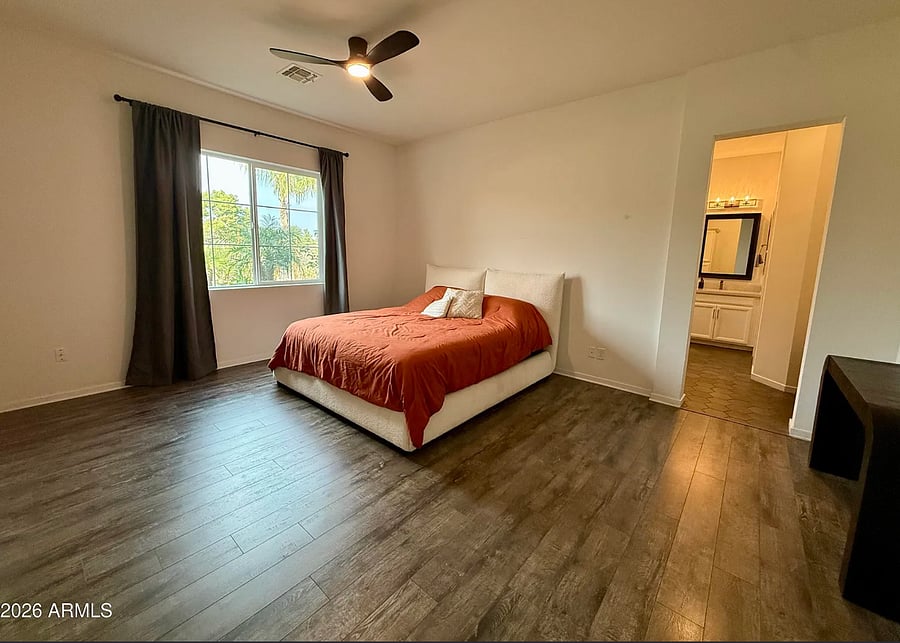 Spacious primary bedroom with natural light, modern flooring, and a clean, relaxing layout.