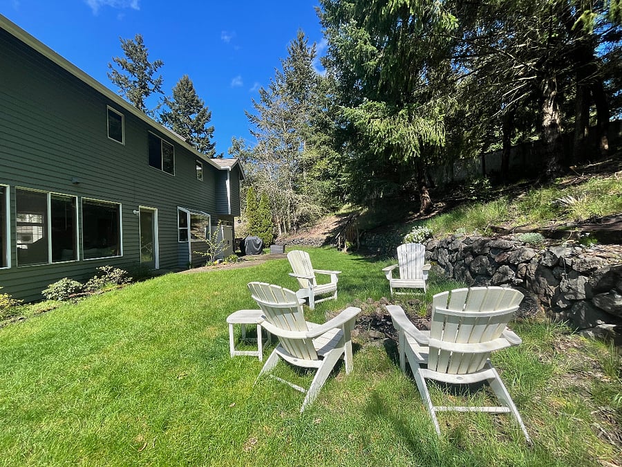 White Adirondack chairs and a fire pit for outdoor relaxing.