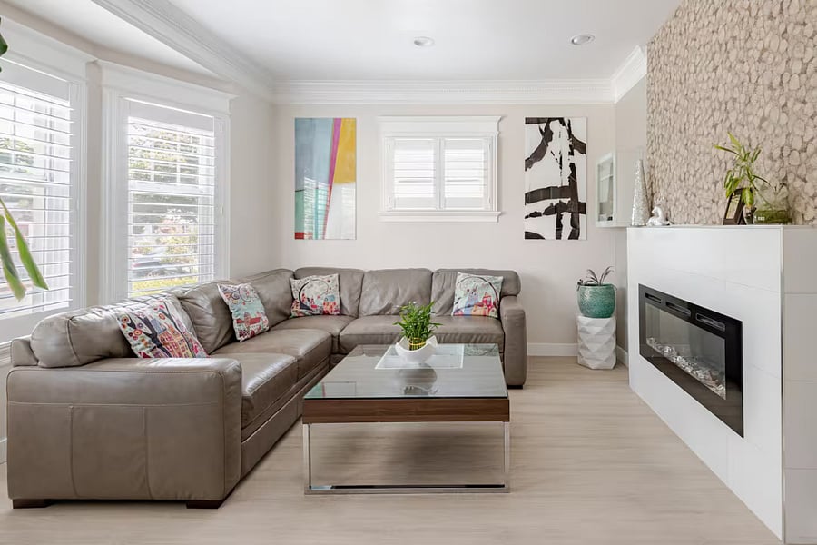 Living Room: Kick back in the beautifully designed living room, featuring a leather sectional, sleek electric fireplace with an organic leaf-textured tile wall, and fresh Craftsman-inspired flooring that adds a welcoming touch.