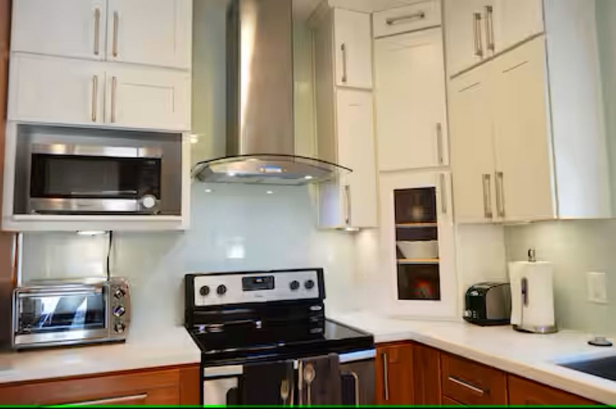 Kitchen: The kitchen corner includes a microwave and a compact toaster oven, ideal for preparing breakfast, snacks, or light meals with ease. A full electric range with a modern hood adds both style and functionality for more complete cooking.