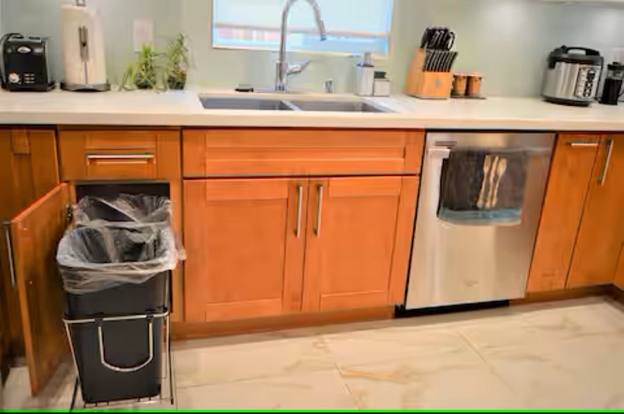 Kitchen: Features a built-in cabinet that discreetly houses two trash cans for a clean and organized look.