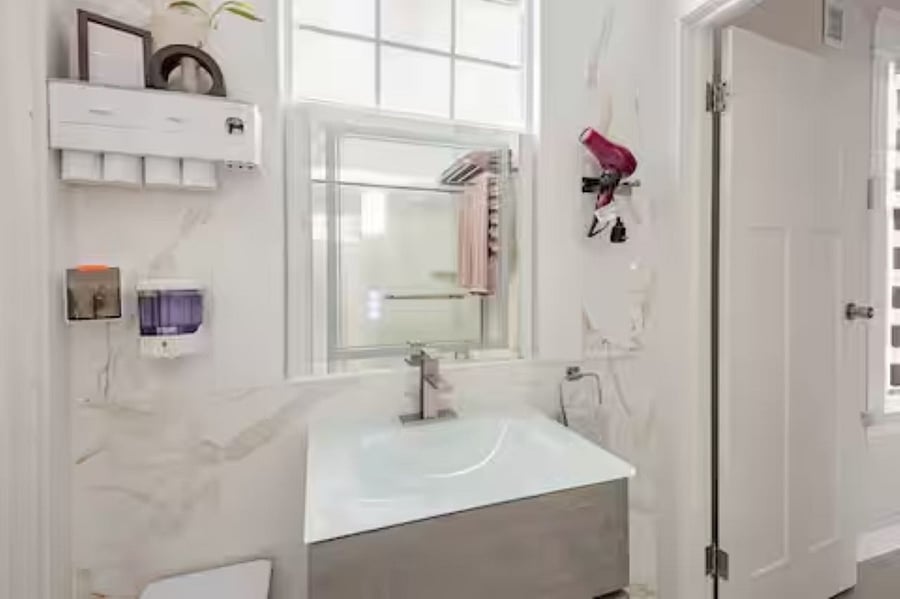 Bathroom 2 : The floating vanity features an integrated glass sink and a smart touch-screen mirror with front lighting, backlit anti-fog technology, and a dimmable memory function, enhancing both modern aesthetics and functionality