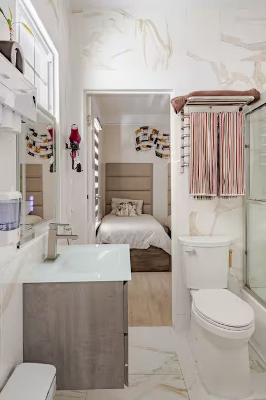 Bathroom #2  Jack and Jill, with dual access from two bedrooms. Fully tiled from ceiling to floor to minimize dust buildup, featuring a sleek wall-mounted vanity, towel warmer, and smart mirror with anti-fog function for comfort and functionality.