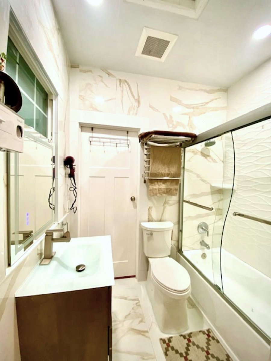 Bathroom #2  Jack and Jill: This streamlined space is tiled floor to ceiling for a crisp, minimalist aesthetic. A slim floating vanity, intelligent mirror, and discreet towel warmer blend form and functionideal for modern living.