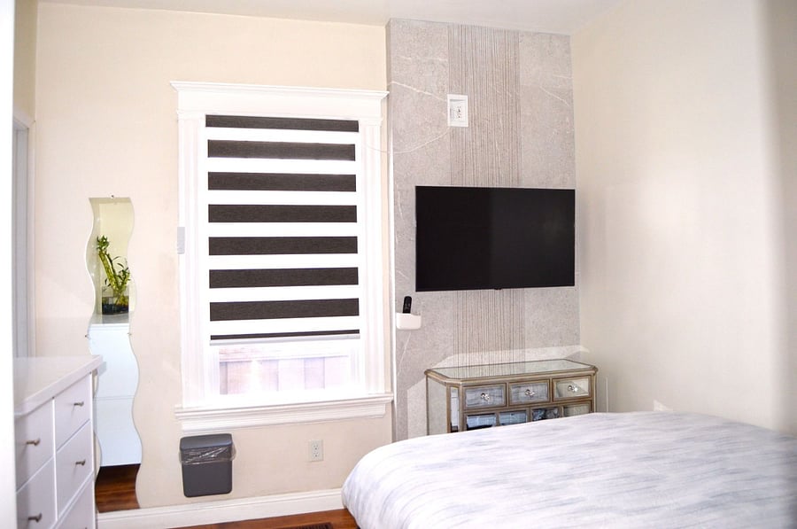 Bedroom #1 (Queen bed) : The smart zebra window shade allows natural light to fill the room, while the beautiful accent TV wall, featuring a smart TV, enhances both style and entertainment